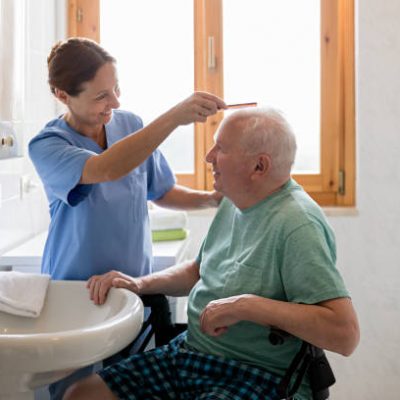 Home Caregiver with senior man in bathroom